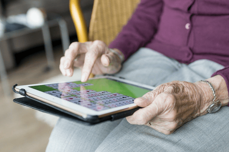iPadでゲームをする高齢者女性の手元の様子